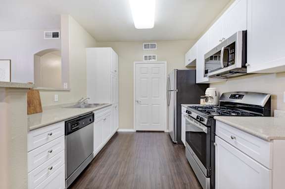 A kitchen with white cabinets and stainless steel appliances.