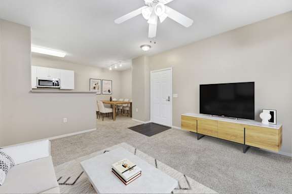 A living room with a television, a chair, a table, and a book on the coffee table.