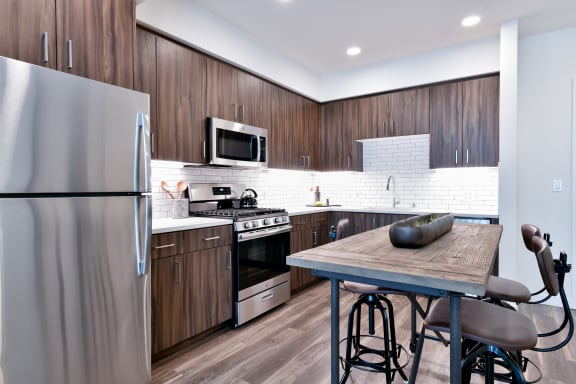 a kitchen with stainless steel appliances and a wooden table