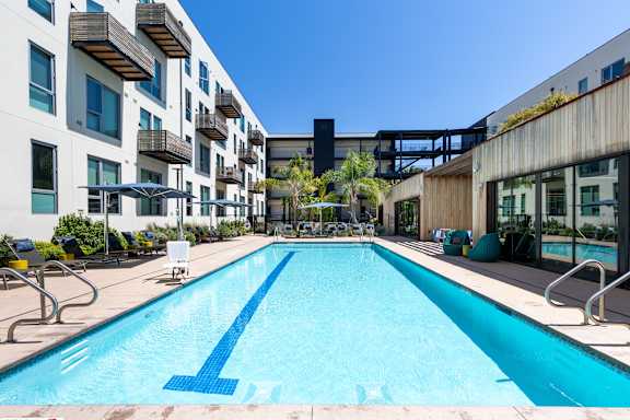 A large blue pool in the middle of a courtyard surrounded by buildings.