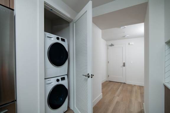 A laundry room with a washer and dryer stacked on top of each other.