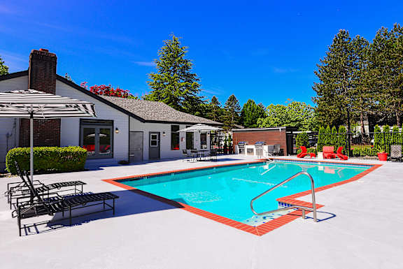 A pool with a red border and a metal ladder at Woodlake Apartments, Kirkland