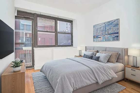 A bedroom with a large bed and a painting on the wall.