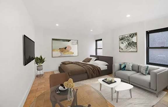 A modern bedroom with a large bed, a couch, and a TV mounted on the wall.