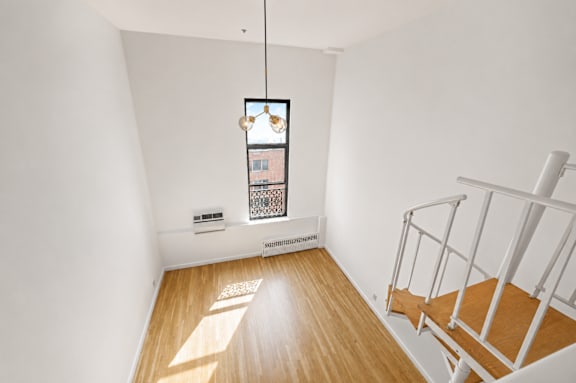 A room with a wooden floor and a staircase.