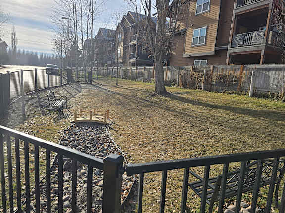 A backyard with a black fence and a small bridge at Mullan Reserve Apartments, Missoula