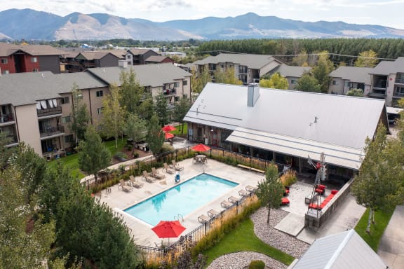 an aerial view of the resort style pool with lounge chairs and umbrellas at Mullan Reserve Apartments, Missoula Montana