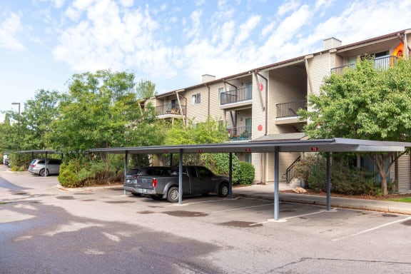 Covered parking area with numbered carport spaces at Mullan Reserve Apartments, Montana