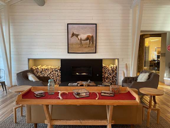 Rustic lounge with fireplace and neatly stacked firewood at Mullan Reserve Apartments, Missoula, MT 59808