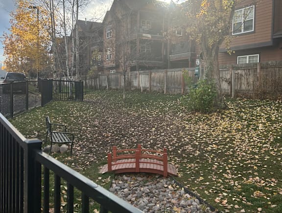 Backyard with ornamental bridge over rock garden at Mullan Reserve Apartments, Montana