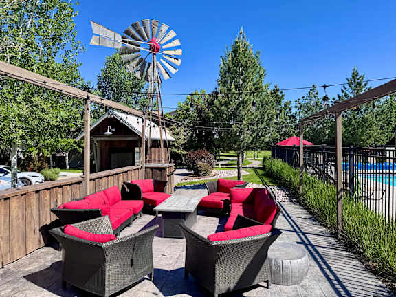 A patio with red couches and a windmill in the background.