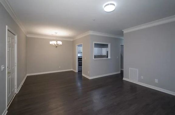 A room with wooden floors and a chandelier at Crest at East Cobb Apartments, Georgia
