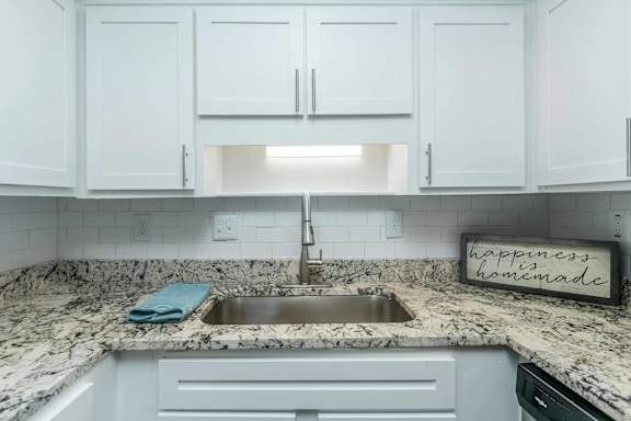 A kitchen with a marble countertop and a sign that says at Crest at East Cobb Apartments, Marietta
