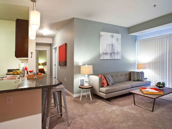 a living room with a couch and a kitchen with a breakfast bar at Mullan Reserve Apartments, Missoula, MT 59808