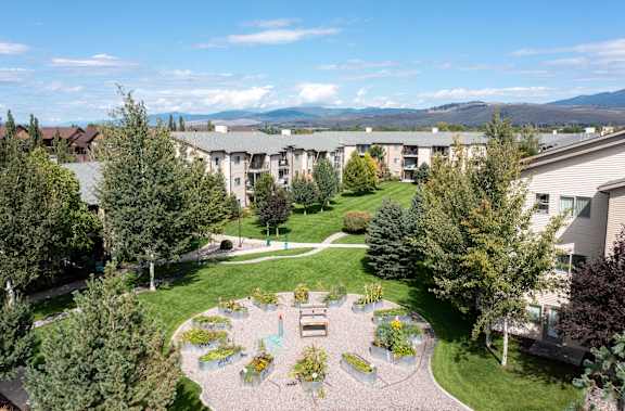 Courtyard garden with walking paths and mature trees at Mullan Reserve Apartments, Missoula