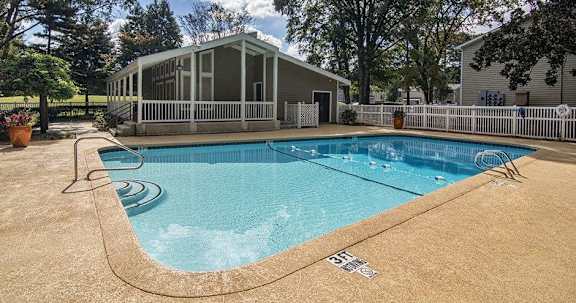 A small pool with a white fence around it.