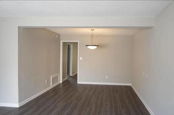 A room with a wooden floor and a light hanging from the ceiling.
