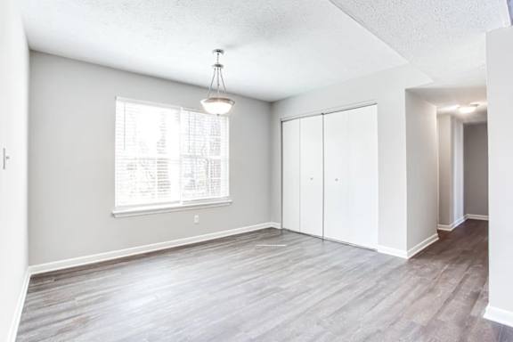A room with a window and a wooden floor.