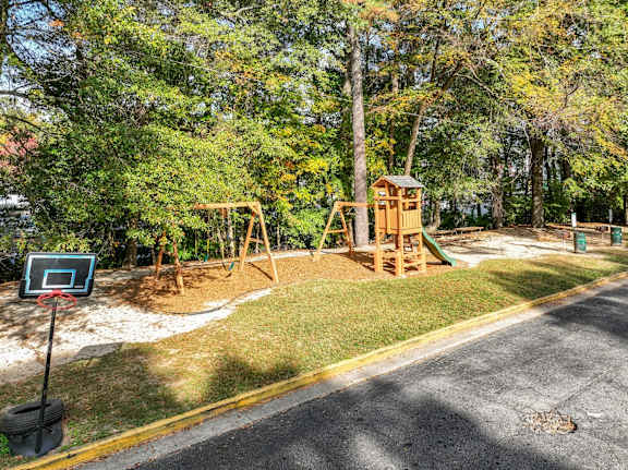 A playground with a basketball hoop and a slide.at Waverly Manor Townhomes, Norcross, GA 30071