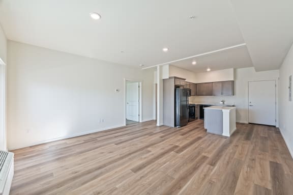 an empty living room and kitchen with wood flooring at Gateway Apartments, East Wenatchee , Washington