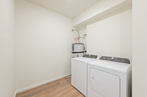 a room with a washer and a dryer in it and a white wall at Gateway Apartments, East Wenatchee , Washington