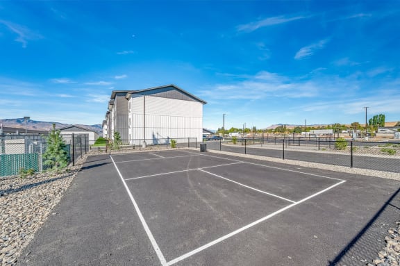 an empty parking lot with a building in the background at Gateway Apartments, East Wenatchee , WA