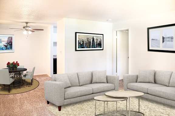 A living room with a grey couch, a coffee table, and a painting on the wall.