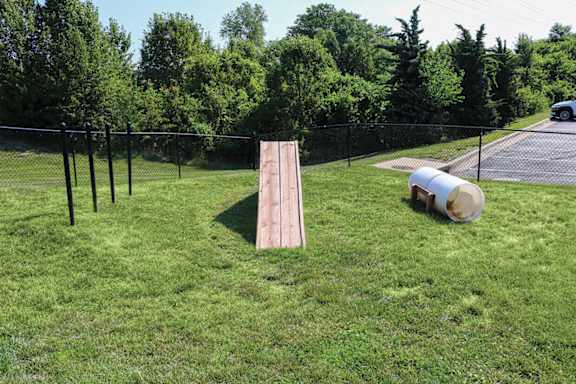 a wooden board in the grass next to a batting cage
