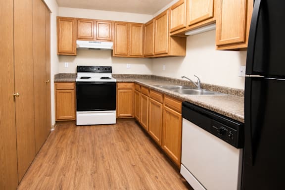 Kitchen with wooden cabinets at Cottages of Topeka, Kansas