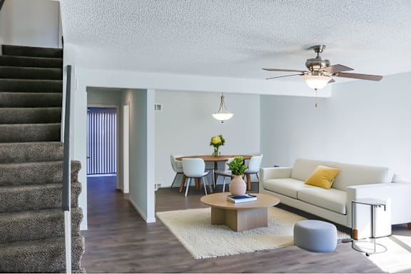 A living room with a staircase on the left side.