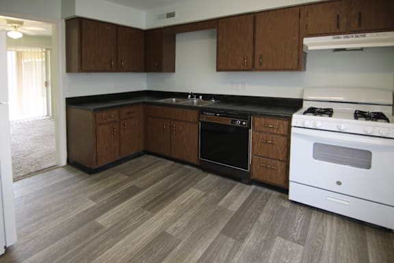 A kitchen with a white stove and wooden cabinets.