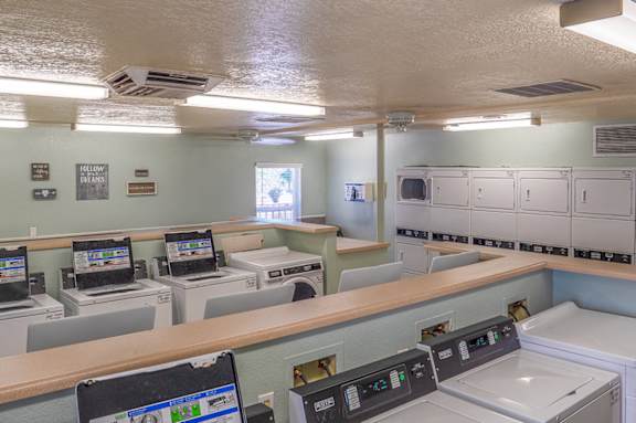 A laundromat with washers and dryers and a sign that says Follow the arrows.