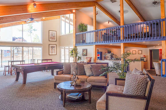 A living room with a pool table and a balcony.