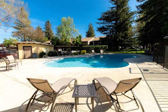 A pool with chairs around it.