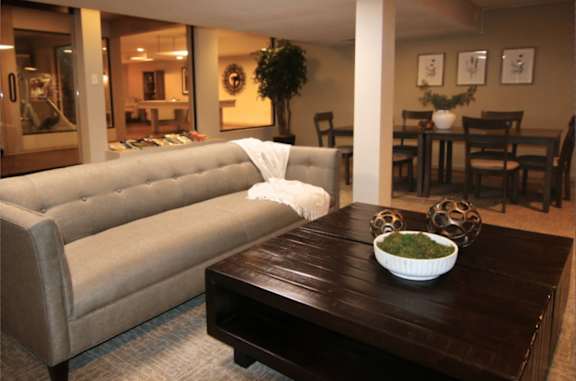 A living room with a couch, coffee table, and dining table.
