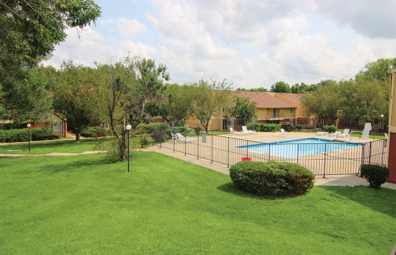 a swimming pool in a yard with a fence