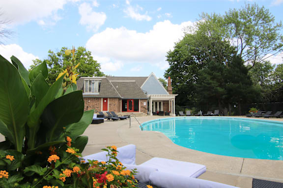 A pool with a house in the background.
