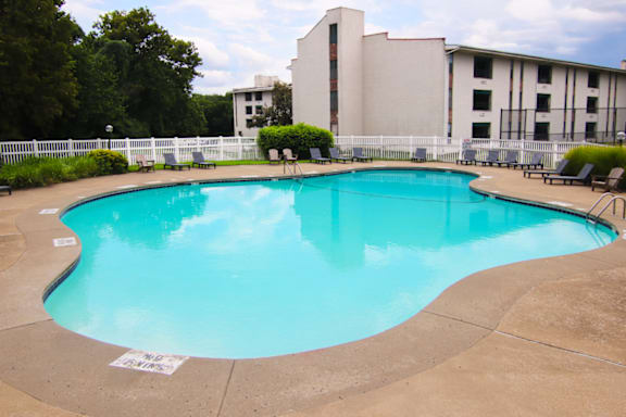A large swimming pool with a white fence around it.