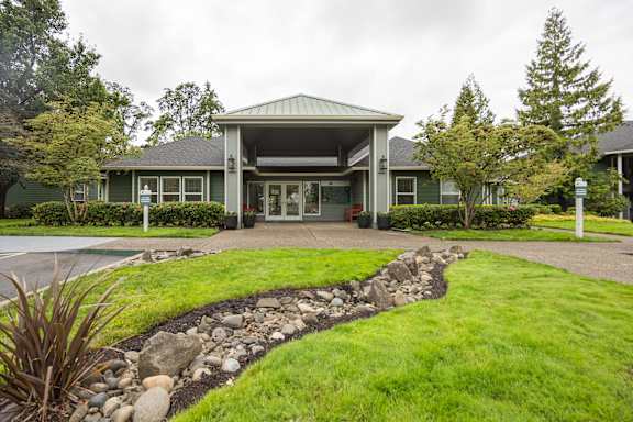 A green building with a stone pathway leading to the entrance.