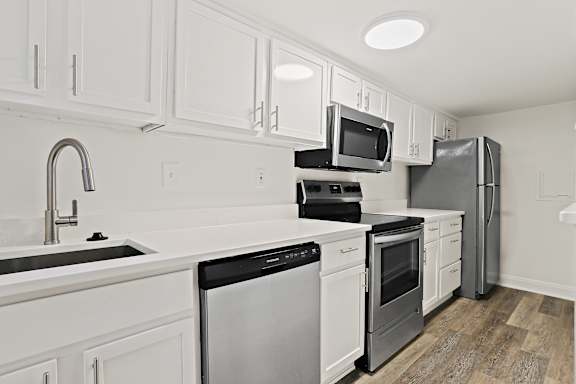 a kitchen with white cabinets and stainless steel appliances