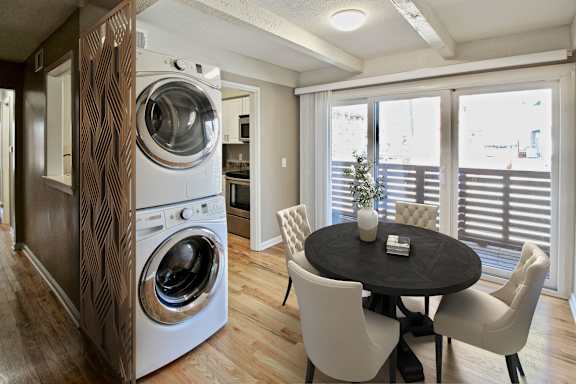 A modern laundry room with a washer and dryer built into a cabinet.