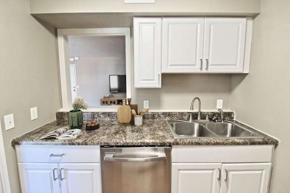 A kitchen with a granite countertop and stainless steel appliances.