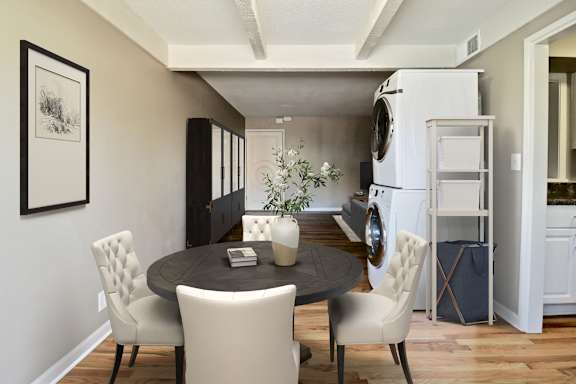 A modern dining room with a round table and four chairs.