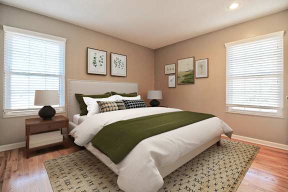 A bedroom with a large bed and a green blanket.