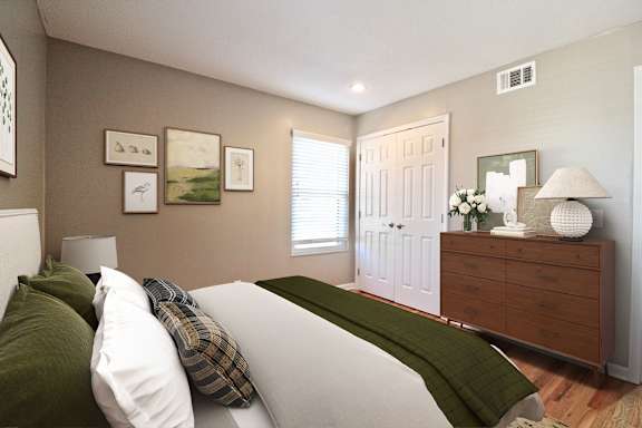 A bedroom with a white bed and green pillows.