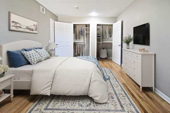 A bedroom with a large bed, a dresser, and a TV.