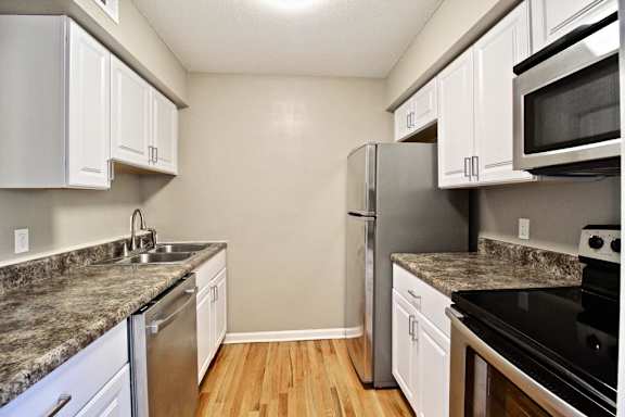 A kitchen with a granite countertop and stainless steel appliances.