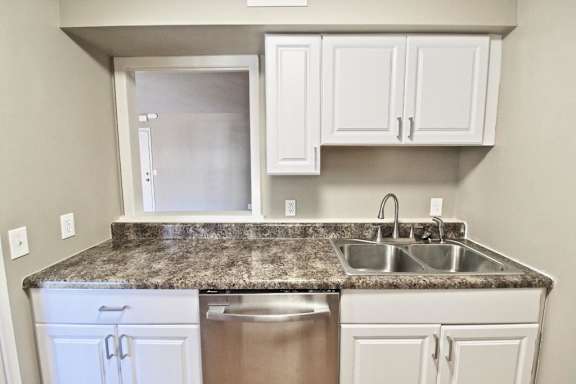 A kitchen with granite countertops and stainless steel appliances.