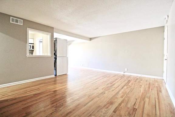 A room with wooden flooring and a white door.