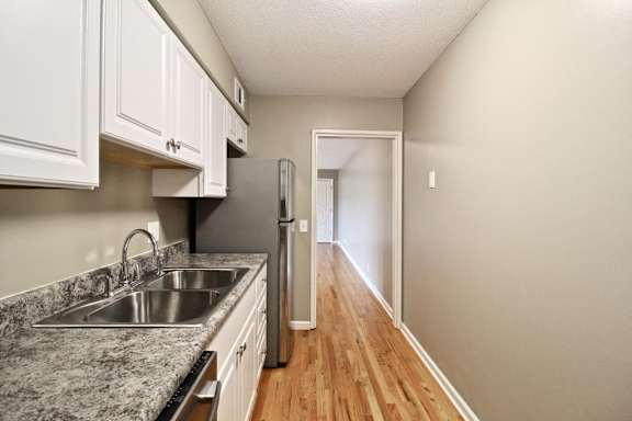 A kitchen with a granite countertop and a refrigerator.